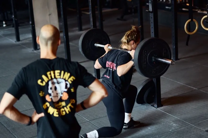 Coach Vince personal trainer Amsterdam coaching female client barbell squat